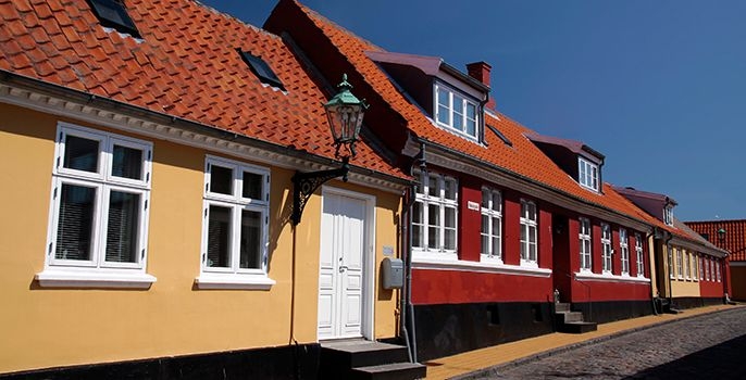 Gult och rött hus vid sidan av varandra med fina fönster från Klar