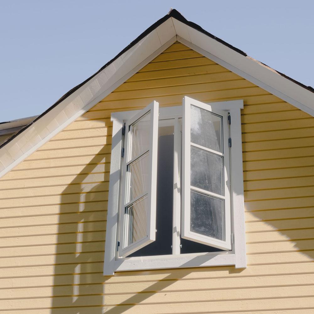 Spröjsade fönster på gult hus